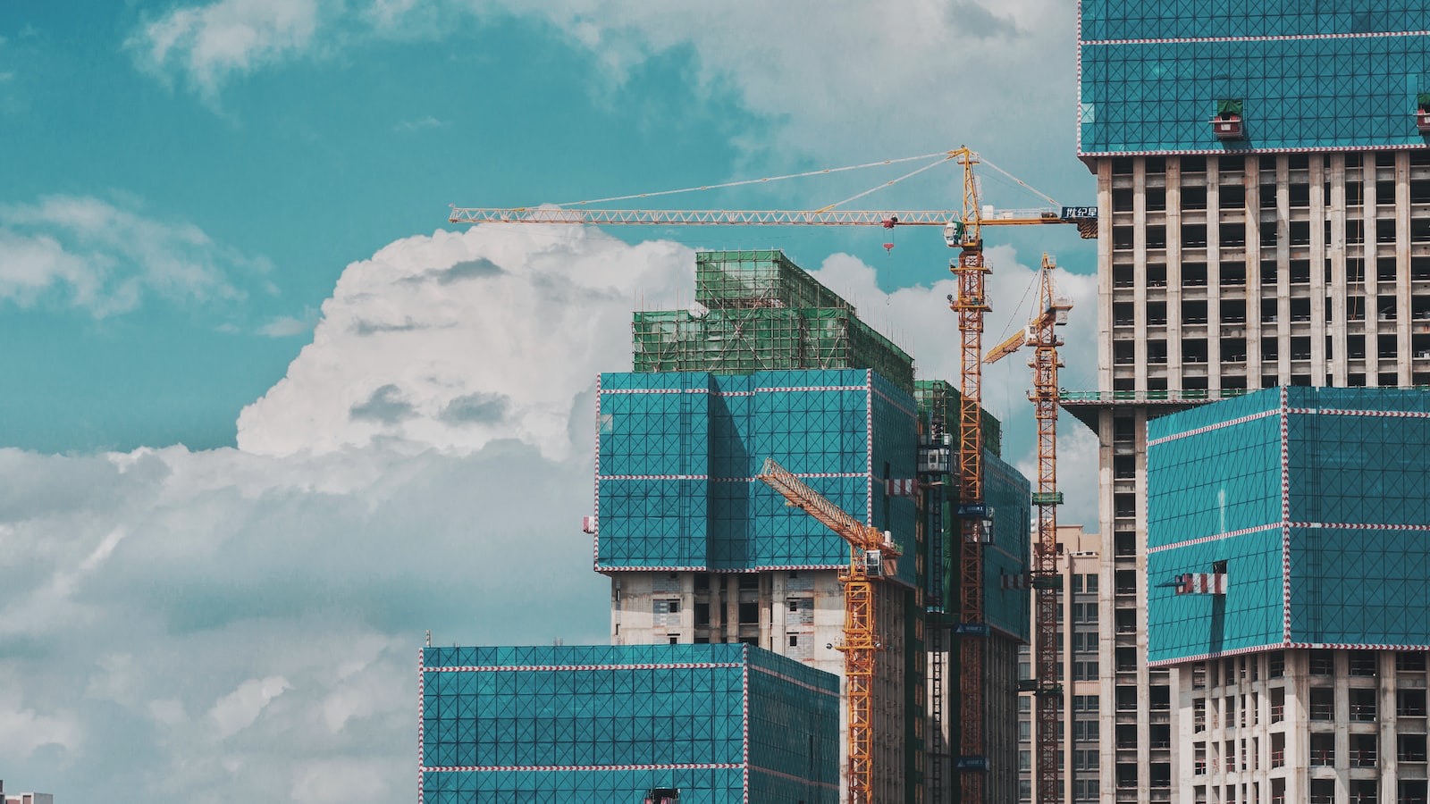 Canteiro de obras com guindastes ao entardecer